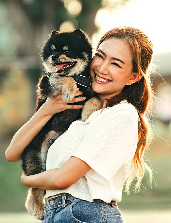 smiling-woman-holding-fluffy-black-and-brown-dog-600x780-2